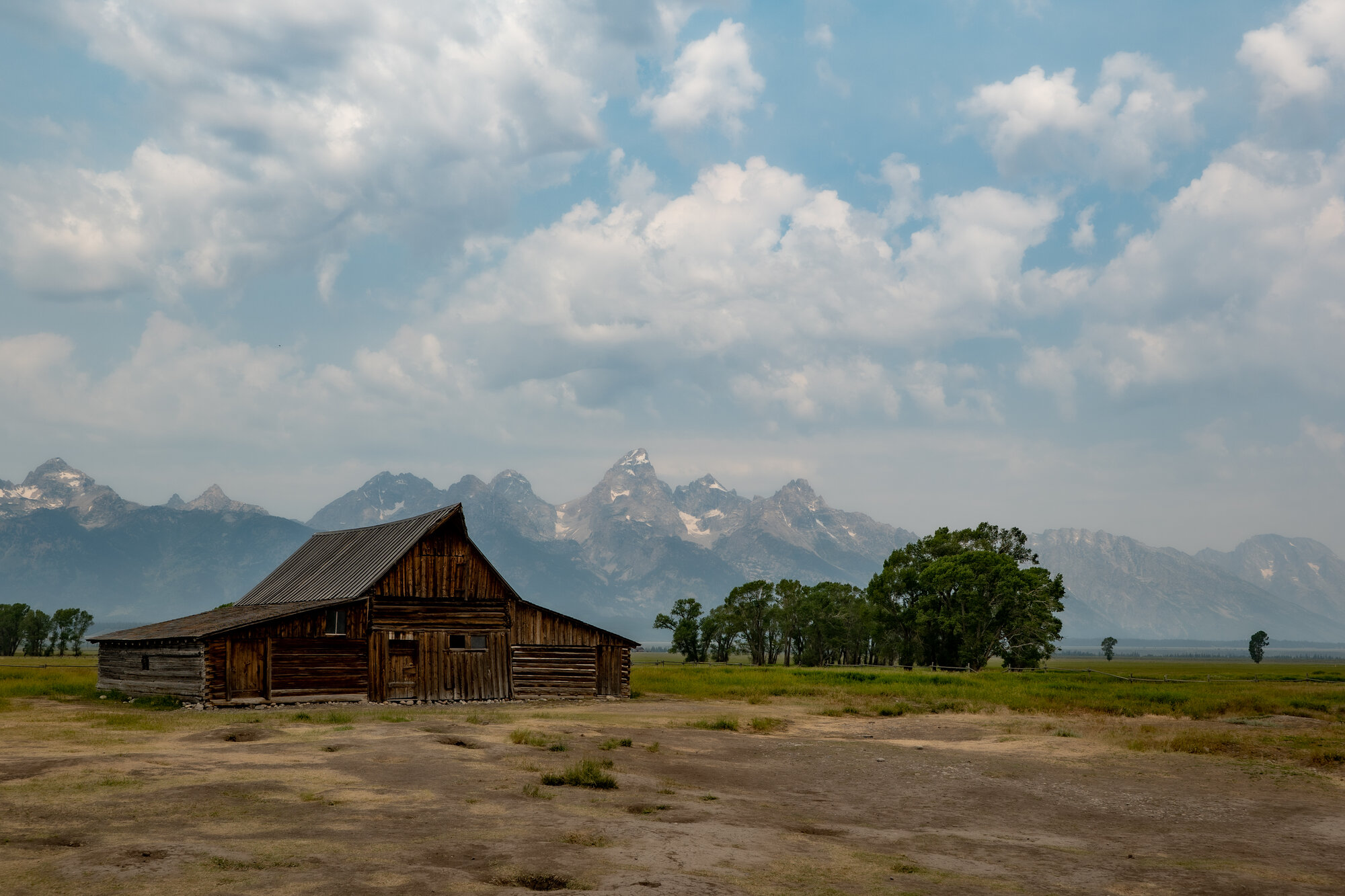 The historic Moulton Barn on Mormon Row in Grand Teton, weathered wood against an open sky with the Teton range behind