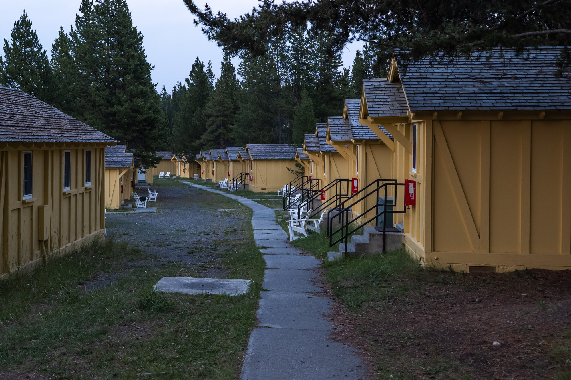 A row of identical yellow cabins at Signal Mountain Lodge in Grand Teton National Park, lit by late evening light
