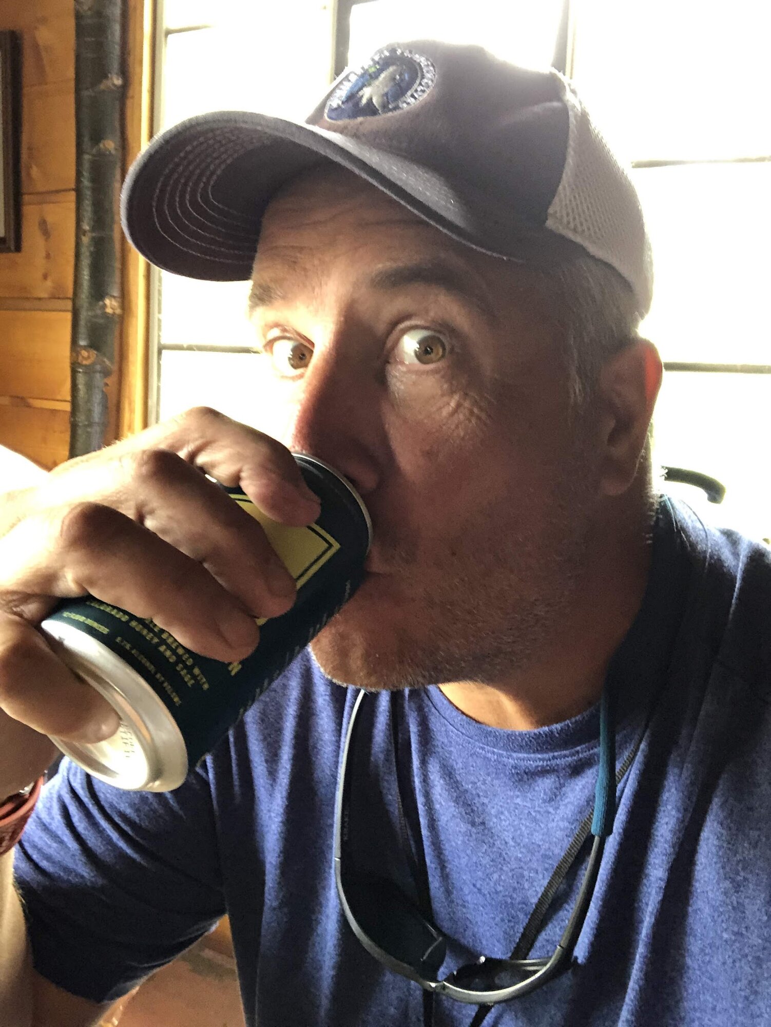 A hiker takes a well-earned pull from a cold beer at Big Sandy Lodge in the Wind River Range, waiting on burgers after two days in the backcountry