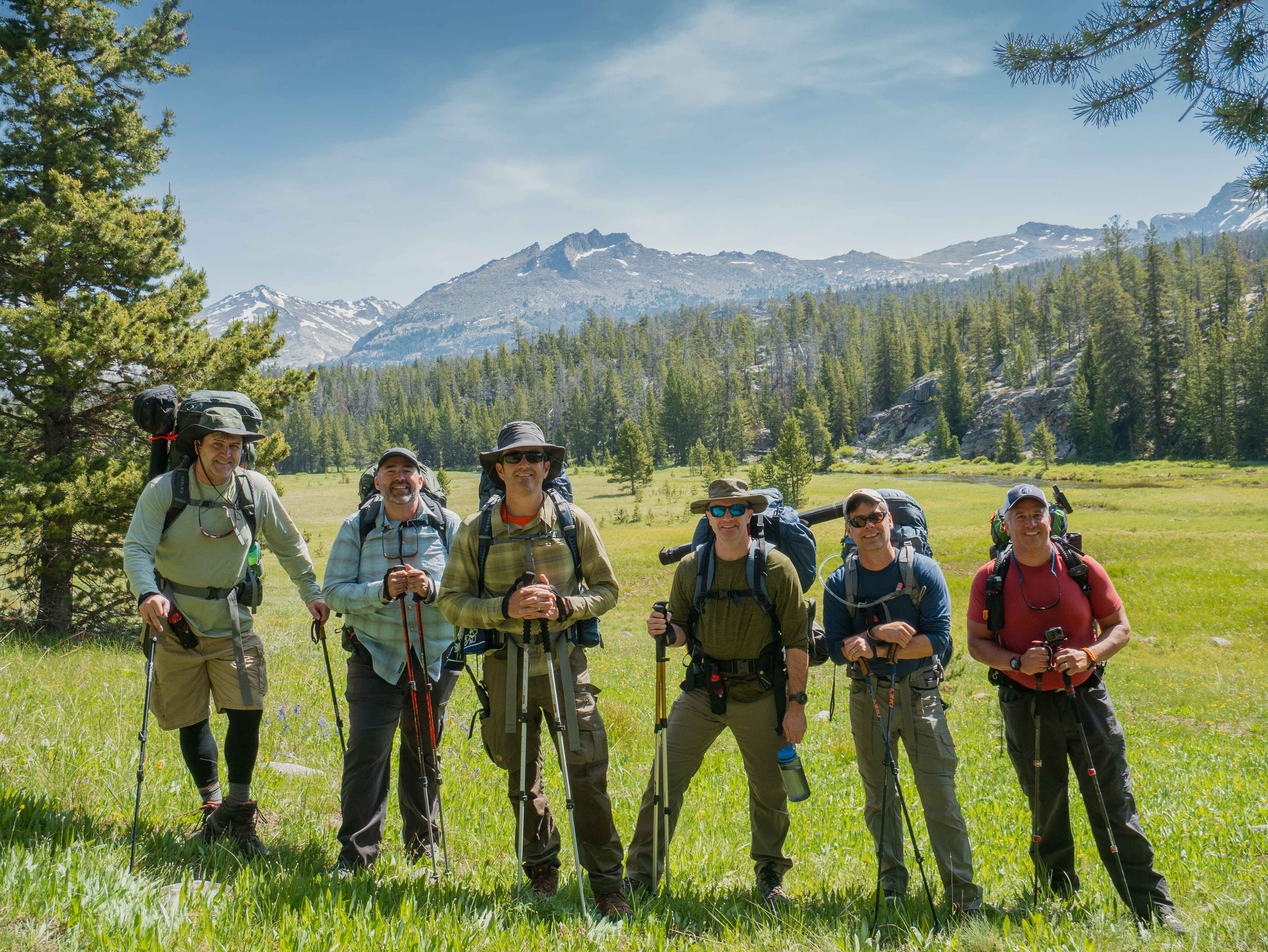 Group of six hikers in the Big Sandy meadow with mountains behind